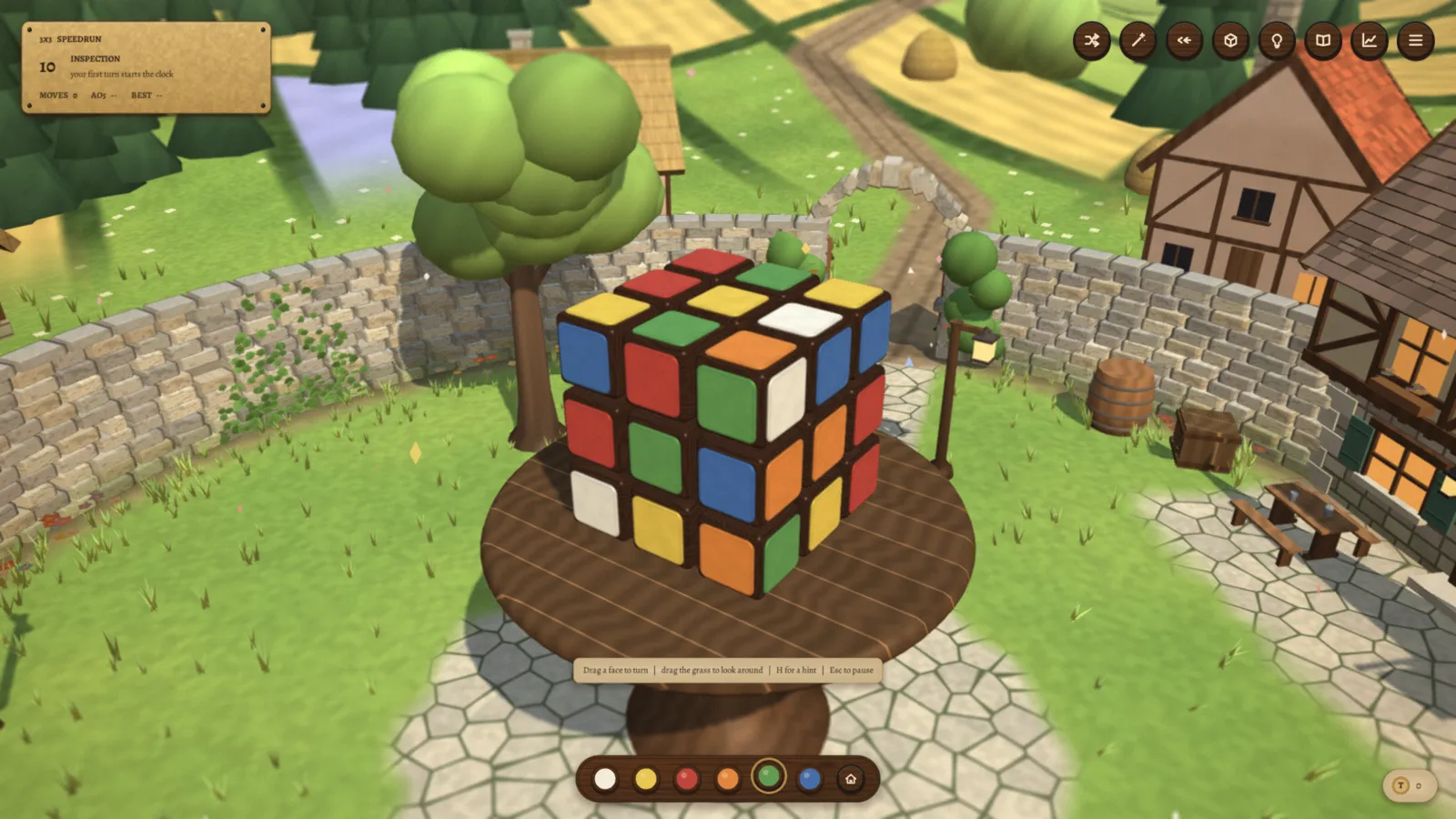 A scrambled cube on a round wooden table in a sunny courtyard, with a stone wall, a tavern and fields behind it.
